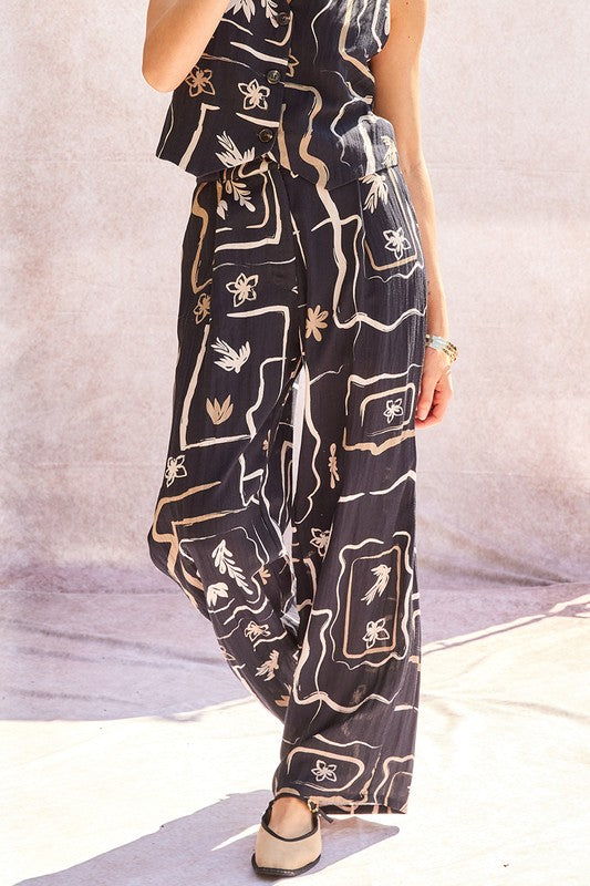 Model walking outdoors in the patterned wide-leg trousers, demonstrating movement.