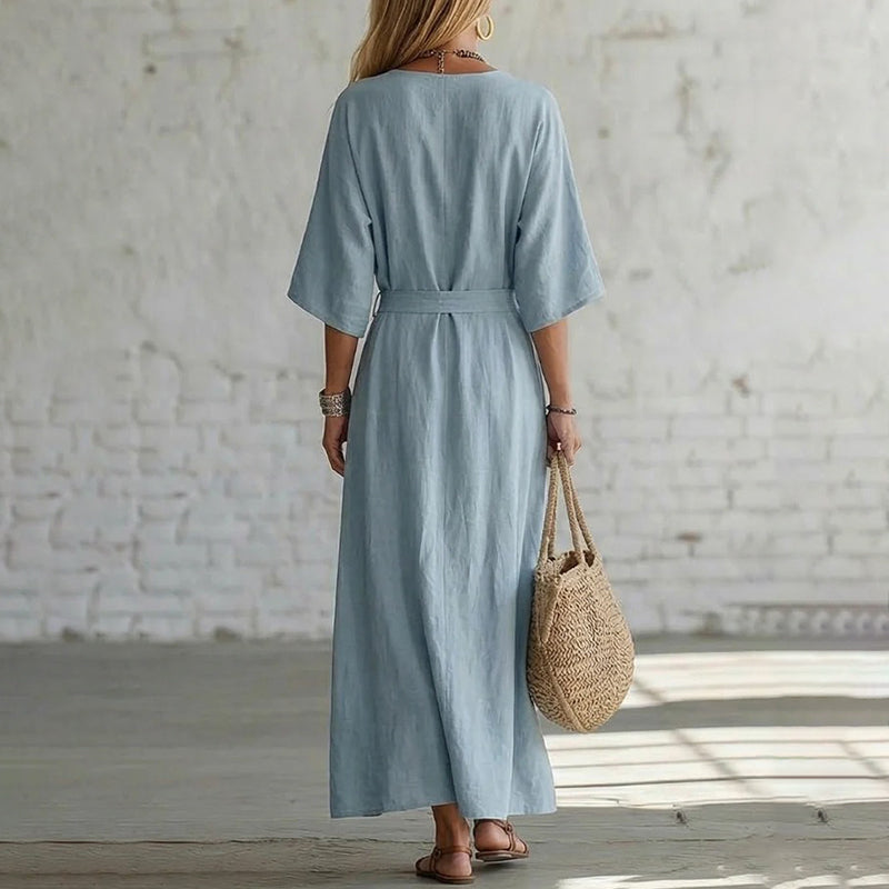 Side profile of a model wearing the Isolde maxi dress in a vibrant orange, demonstrating its comfortable fit.