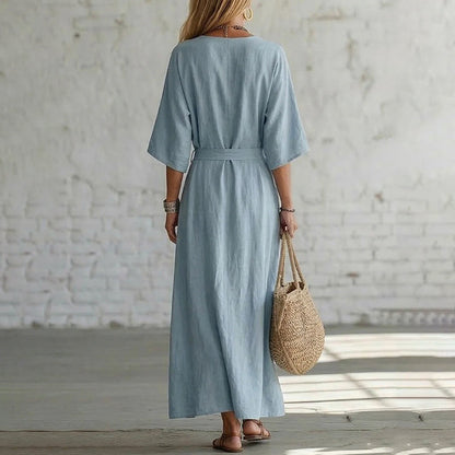 Side profile of a model wearing the Isolde maxi dress in a vibrant orange, demonstrating its comfortable fit.