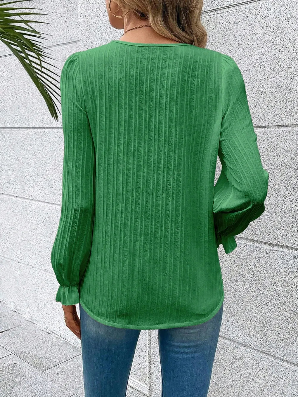 A stack of the Seraphine elegant V-neck lace detail blouses in various colours, neatly arranged.