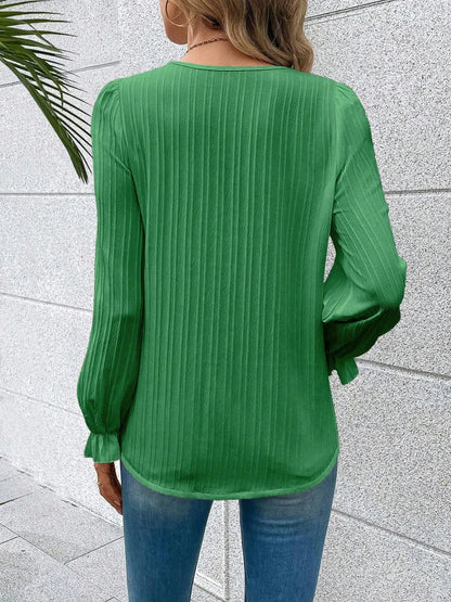 A stack of the Seraphine elegant V-neck lace detail blouses in various colours, neatly arranged.