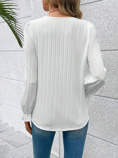 Side profile of the white Seraphine blouse, highlighting the flowing flounce sleeves and relaxed fit.