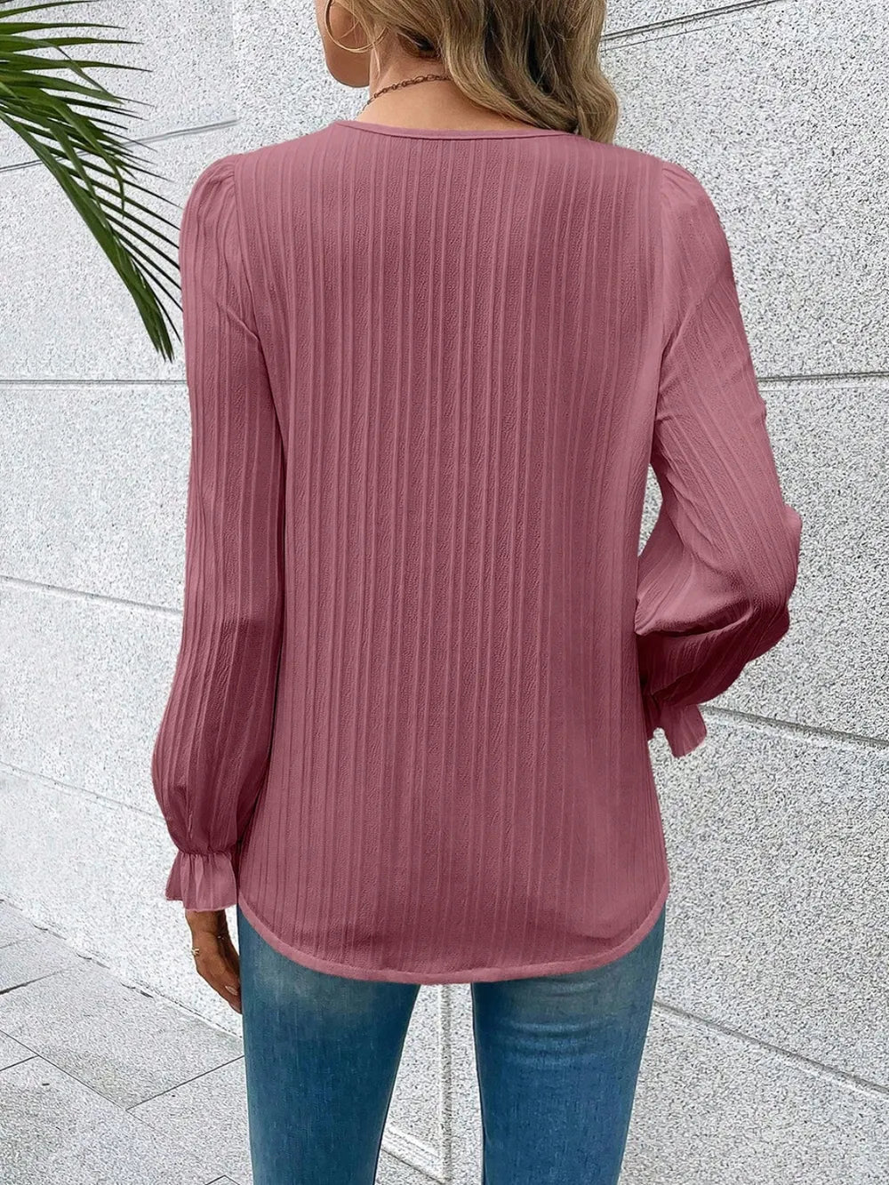 Detail shot of the flounce sleeve on the sky blue Seraphine blouse, capturing its gentle movement.