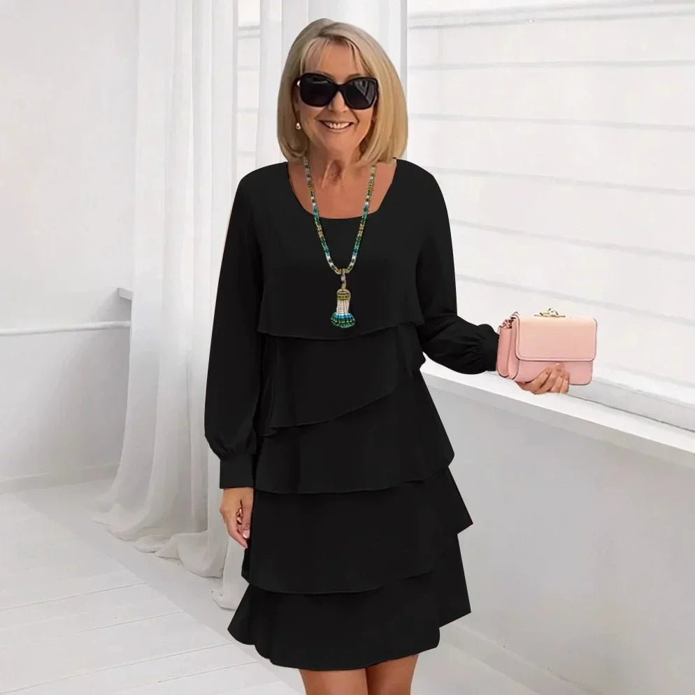 Front view of the Serena elegant ruffle dress in black, showcasing its flowing A-line silhouette and long sleeves.