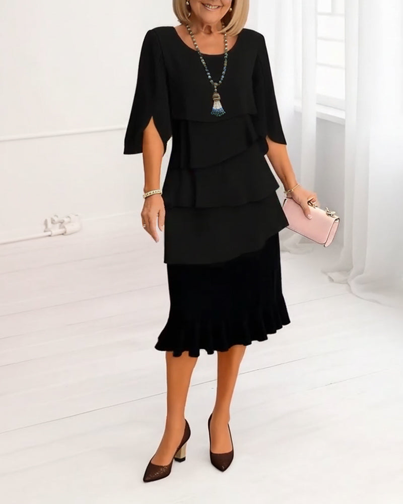 Side profile of the black Serena elegant comfort ruffle dress, showcasing the flowing midi length and split sleeves.