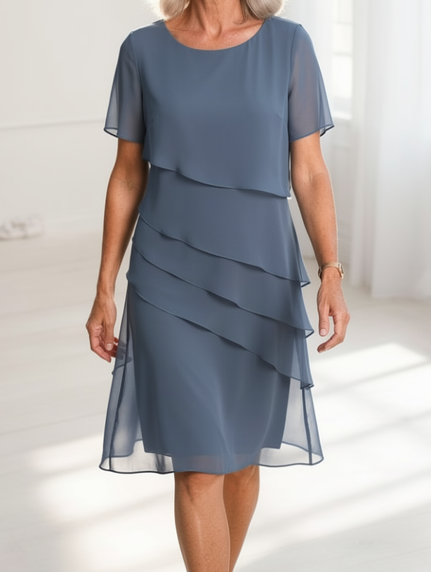 Side profile of a model wearing the Calla elegant ruffle midi dress, highlighting the sheer short sleeves.