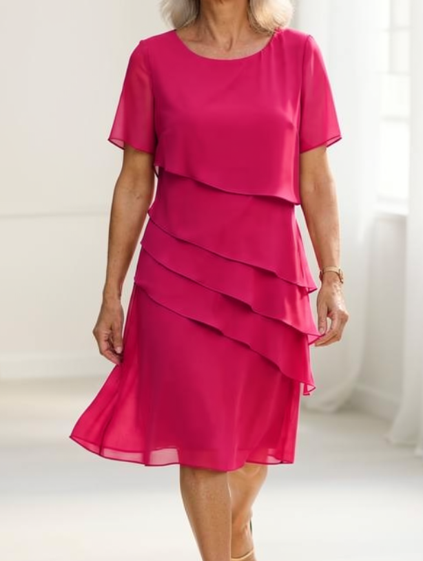Texture detail of the lightweight chiffon material of the elegant ruffle midi dress in a vibrant pink hue.