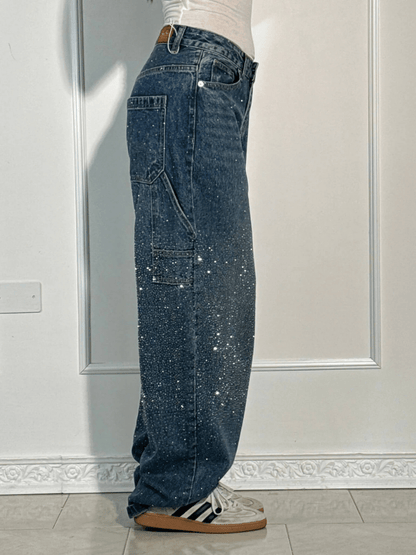 Close-up detail of the embellished stitching and fabric texture on the dark blue balloon carpenter jeans.