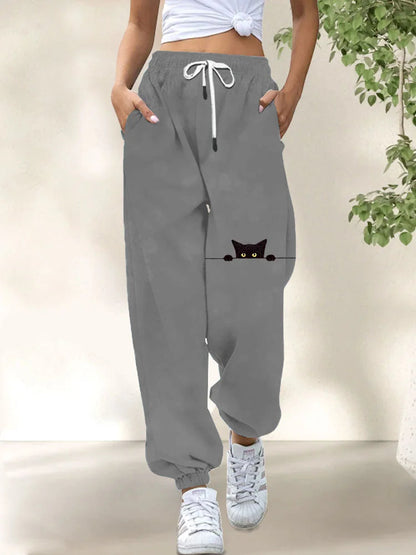 Front view of women's casual cat print trousers in a dark grey colour, showcasing the full leg length and playful pattern.