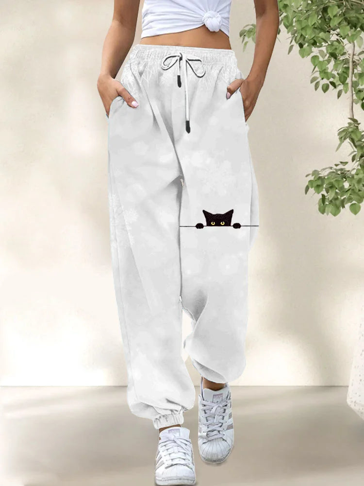 Side view of a woman wearing the Elara casual cat print trousers, styled with a simple top, demonstrating the relaxed fit.