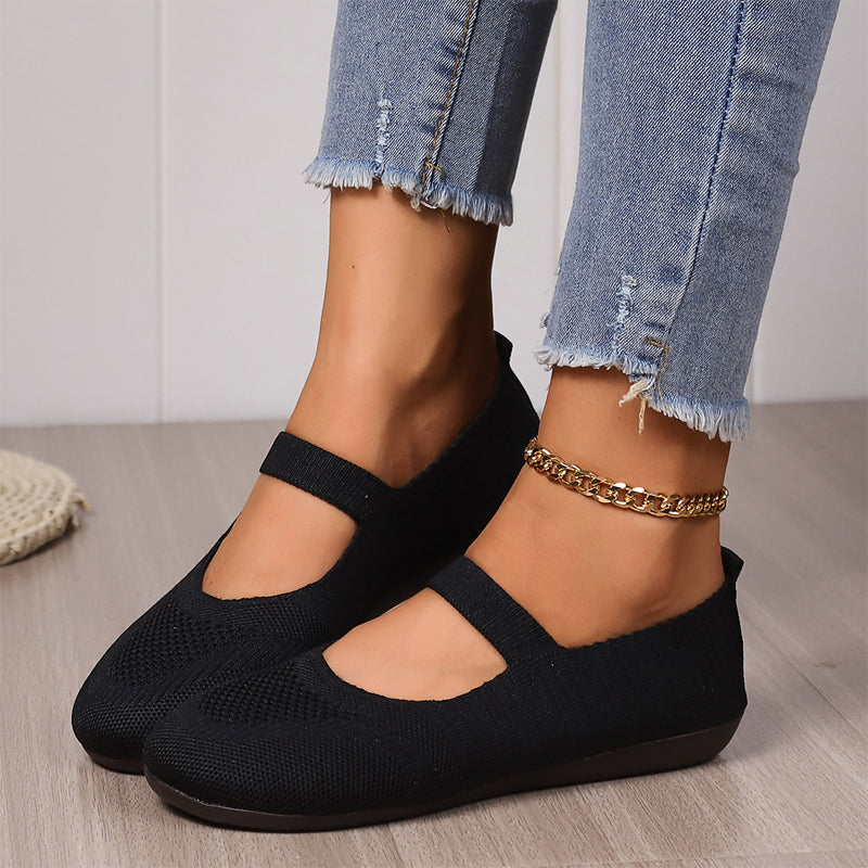 Woman slipping on a pair of comfortable Linnea ballet flats, illustrating the ease of wear.