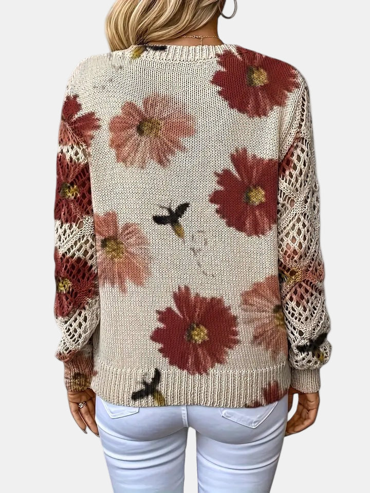 Red floral knit V-neck sweater draped over a chair, highlighting its versatile appeal.