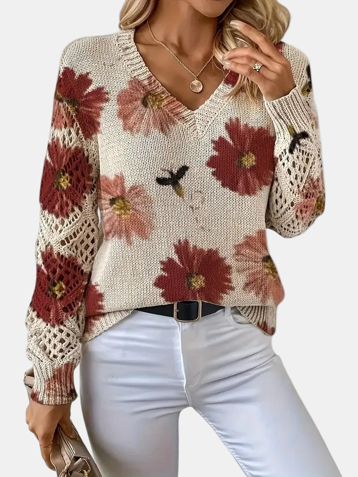 Model smiling while wearing a red floral knit V-neck sweater, conveying comfort and happiness.