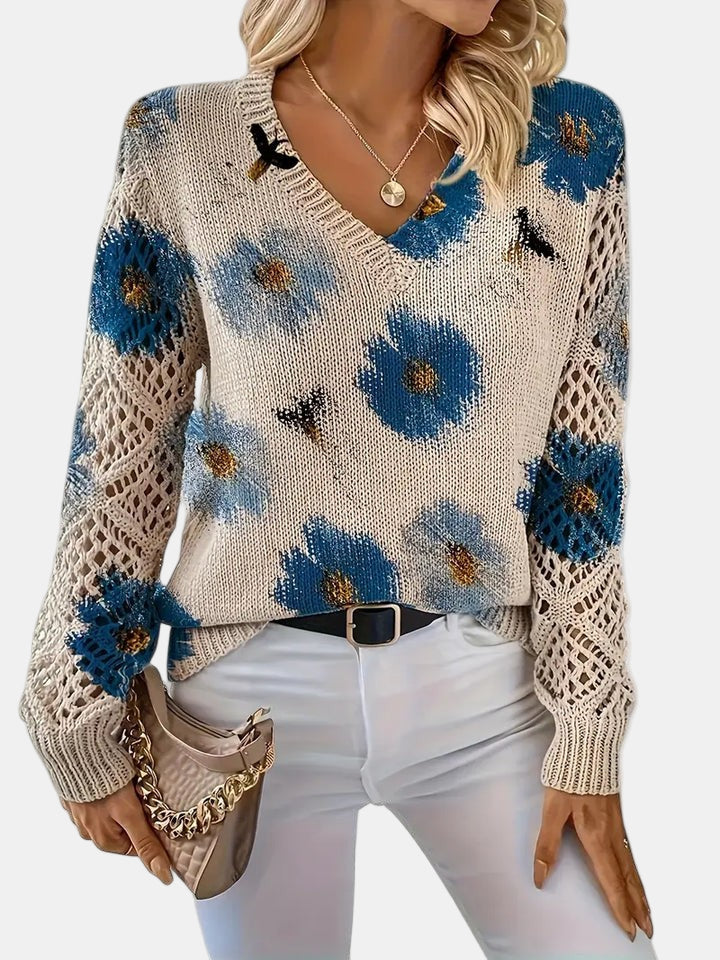 Front hem detail of a green floral knit sweater, with a focus on the ribbed band.
