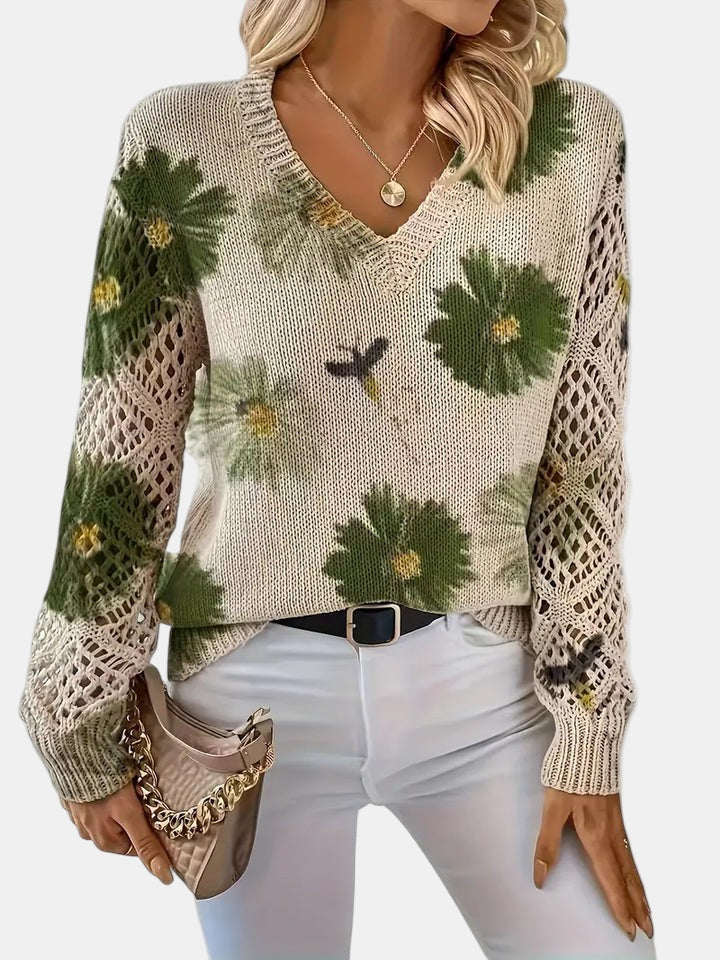 Woman walking in a park, wearing a purple floral knit V-neck sweater, full body shot.