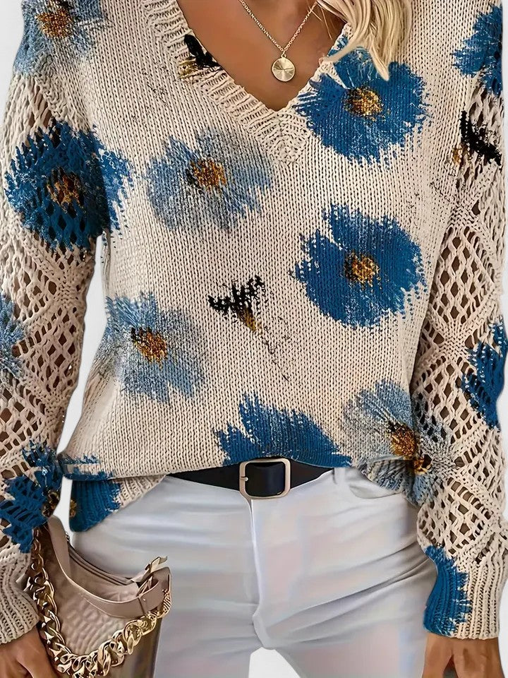 Close-up of the shoulder seam and V-neck on a green floral knit sweater, demonstrating construction.