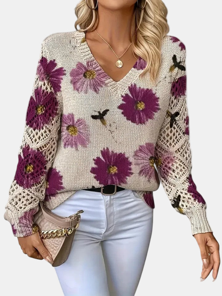Back view of a purple floral knit sweater, displaying the full design and ribbed hem.