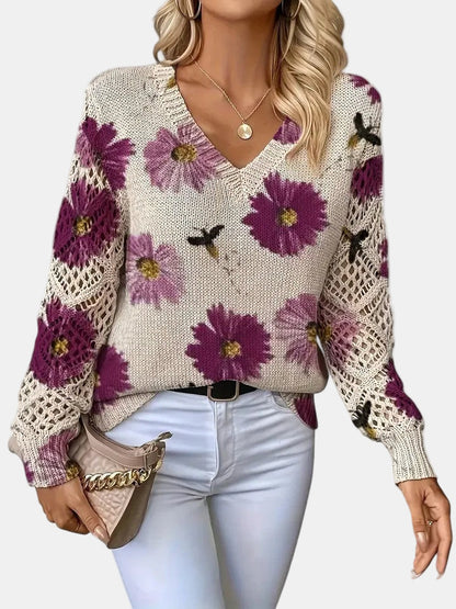 Back view of a purple floral knit sweater, displaying the full design and ribbed hem.