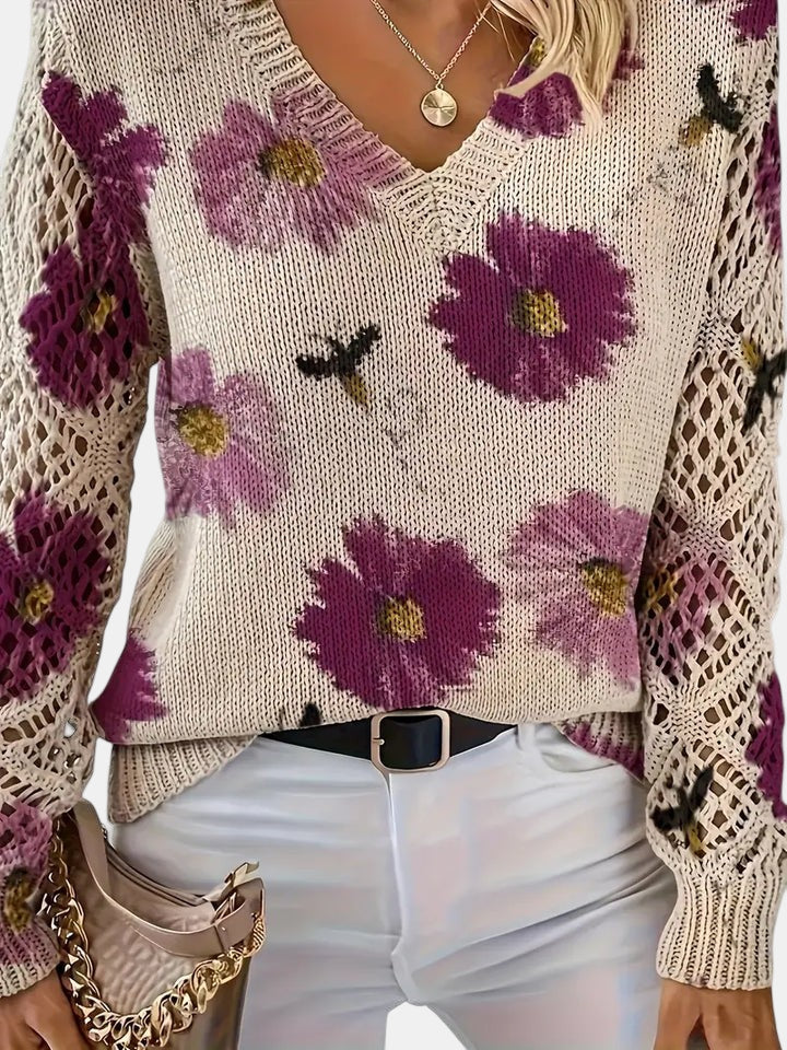 Flat lay of a blue floral knit V-neck sweater, neatly folded to show the fabric and pattern.