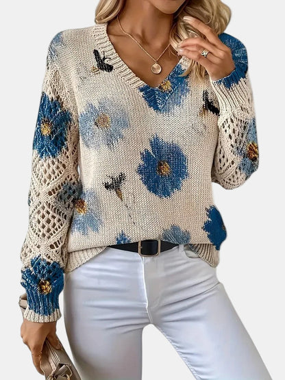 Close-up of the V-neckline on a green floral knit sweater, focusing on the stitch detail.