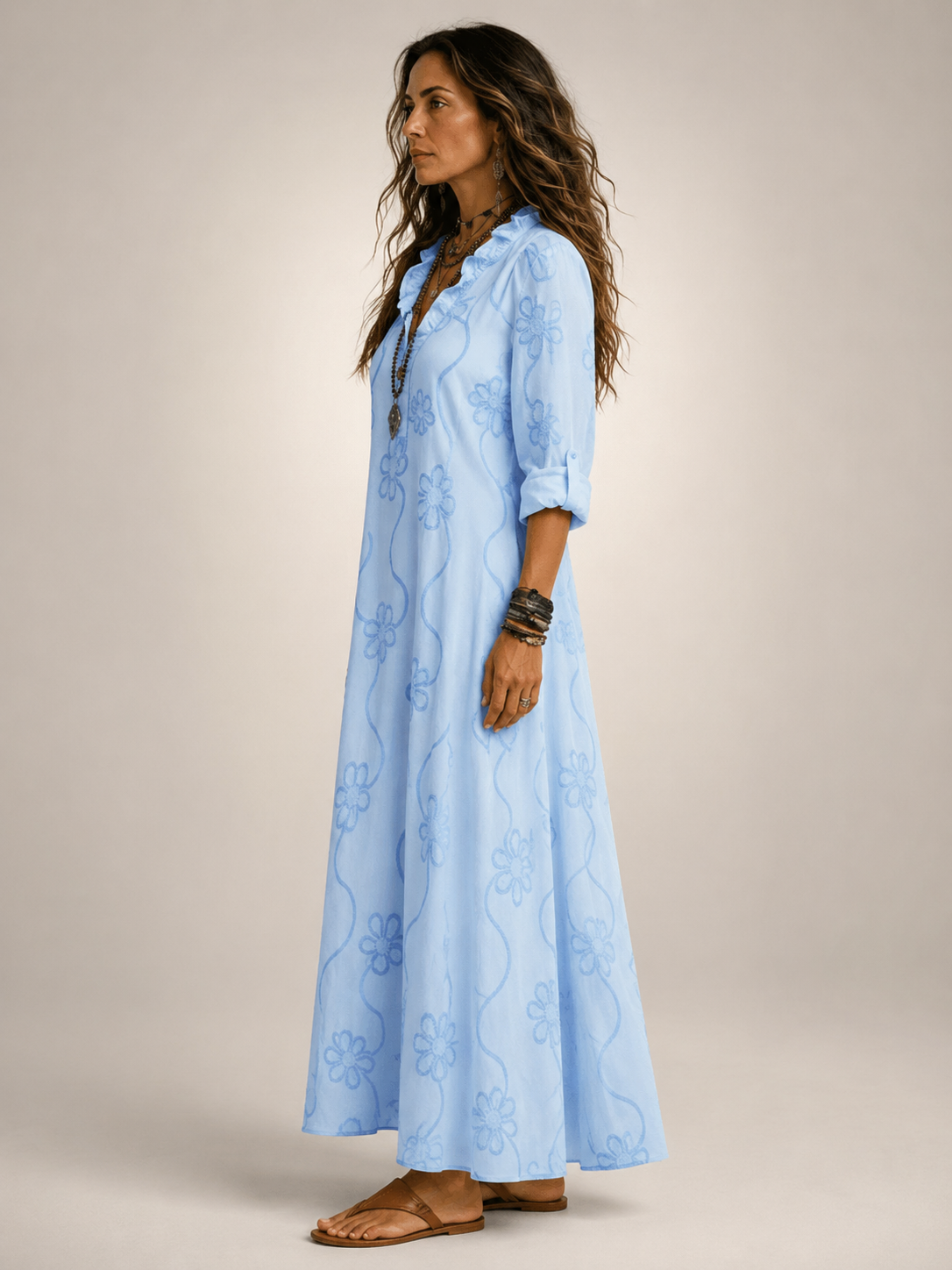 Front view of a woman wearing the white Lotte floral flowing maxi dress, in a bright outdoor setting.
