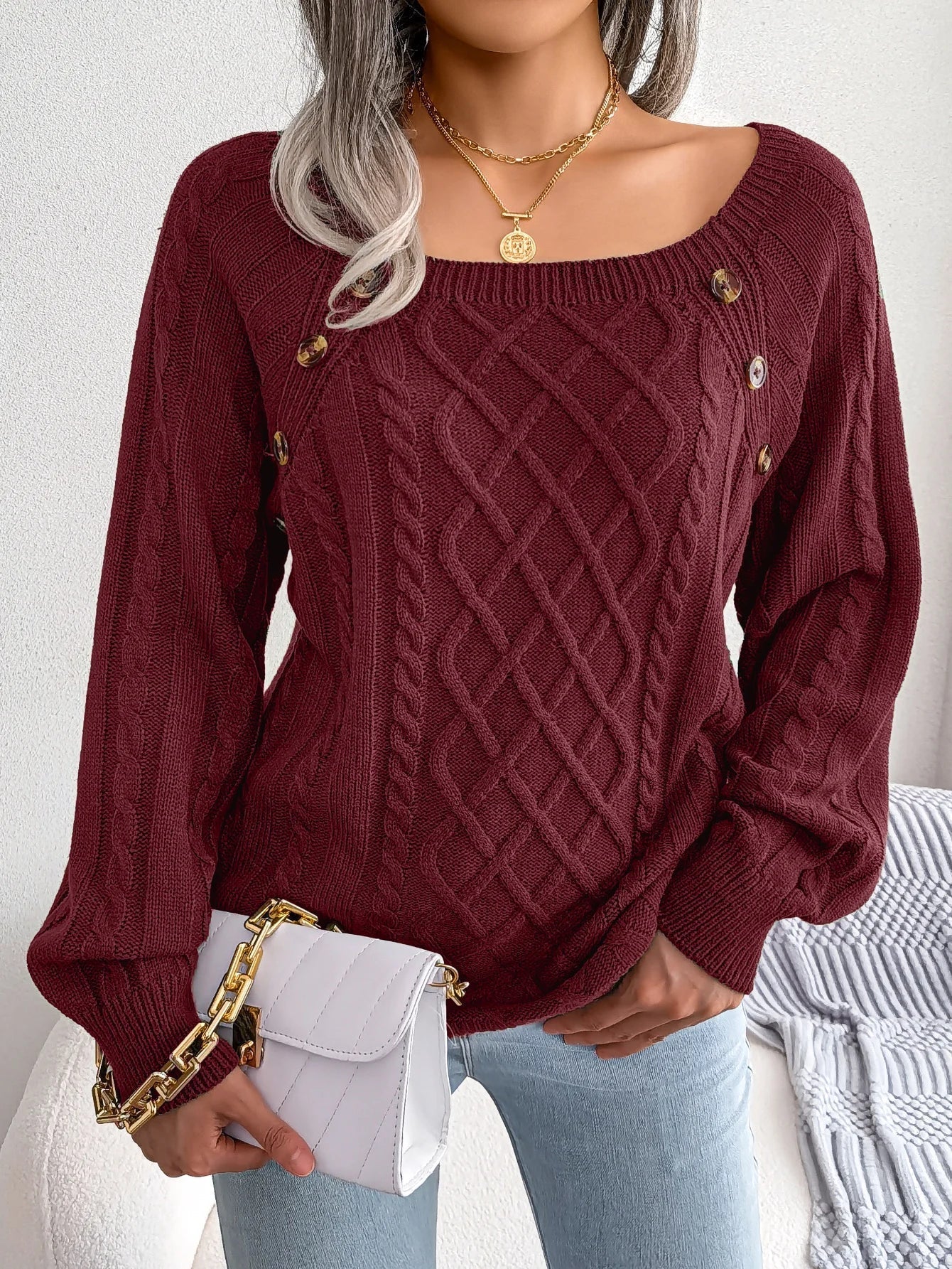 Close-up of the neckline and button embellishments on the khaki casual knitted sweater.