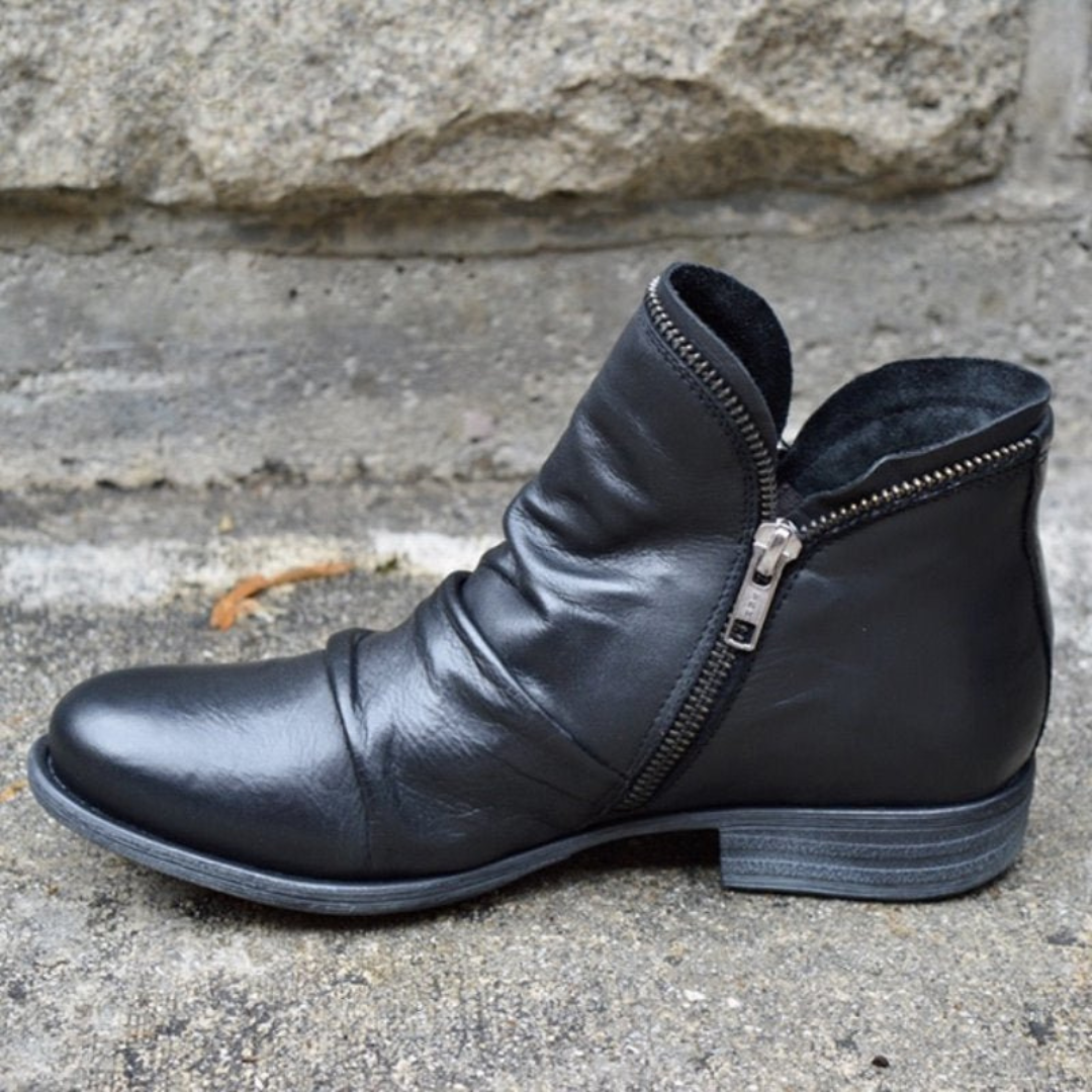 Side profile of a black Hadley ankle boot, highlighting the practical side zip closure and low block heel.