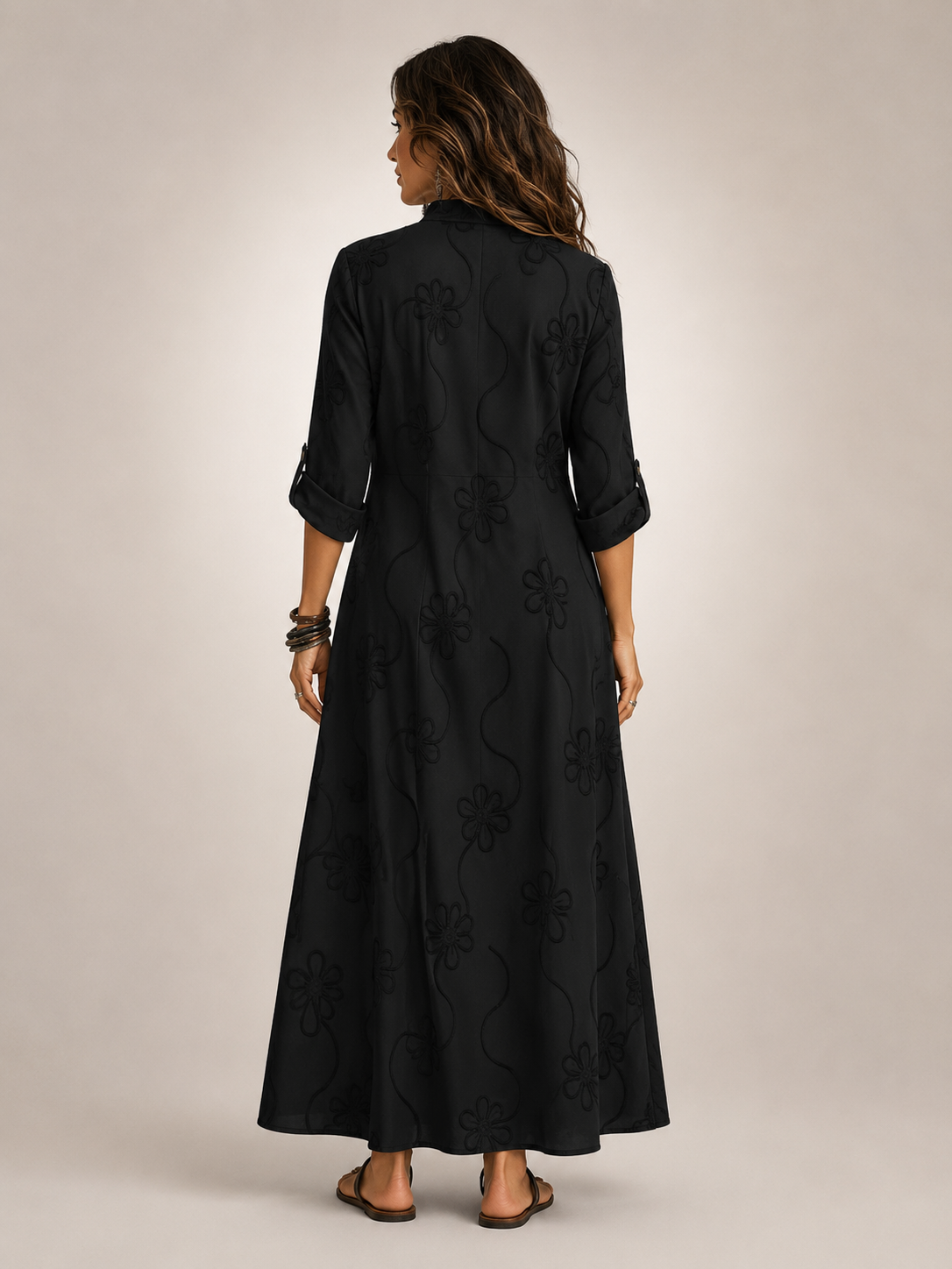 Front view of a woman wearing the black Lotte floral flowing maxi dress, posing elegantly.