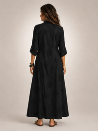 Front view of a woman wearing the black Lotte floral flowing maxi dress, posing elegantly.
