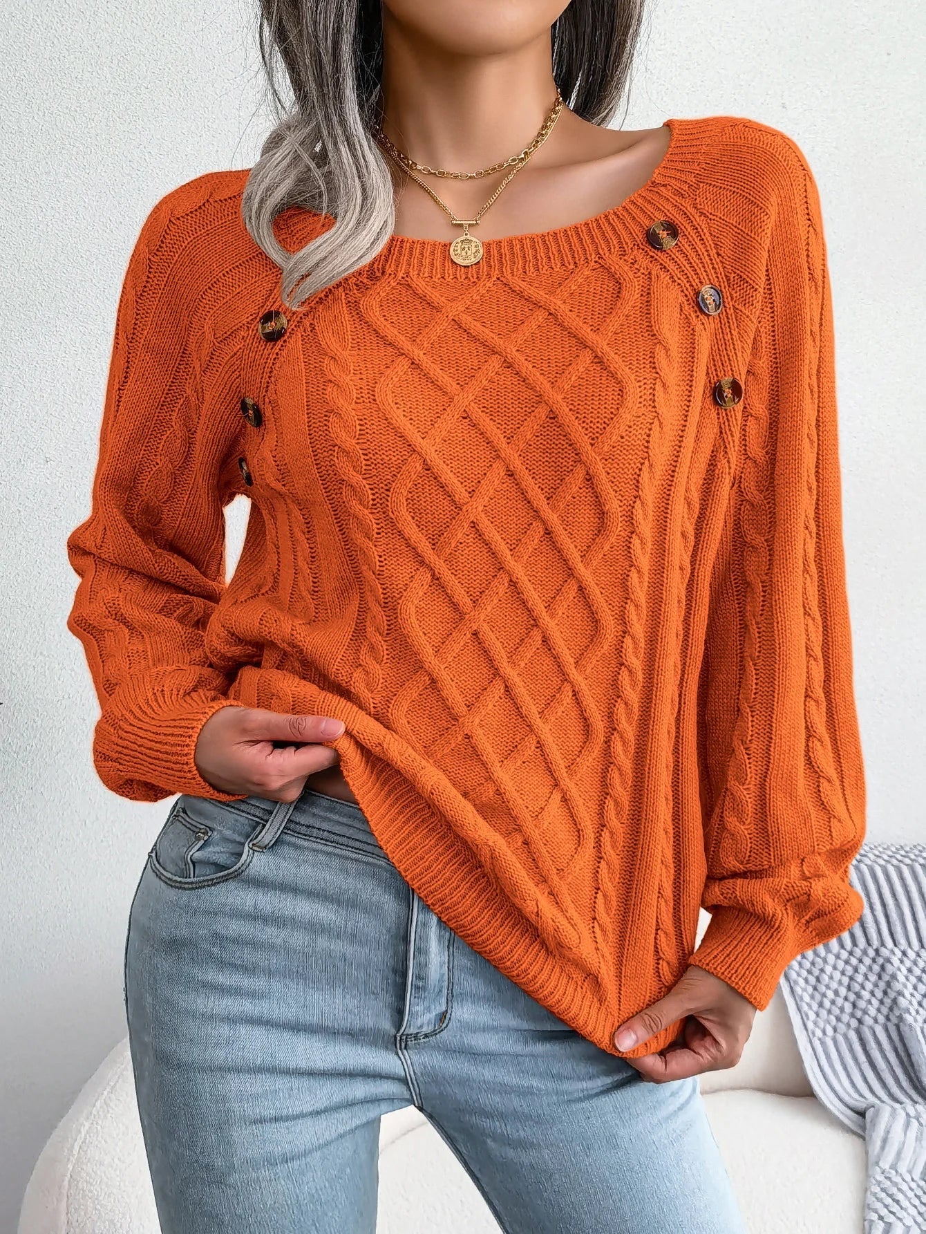Lifestyle image of someone enjoying a cup of tea while wearing the orange casual knitted sweater.
