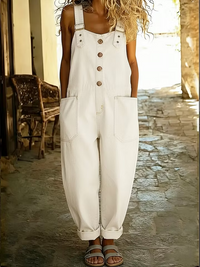 Side profile of a woman in the dark wash casual denim jumpsuit, illustrating the relaxed silhouette and overall design.