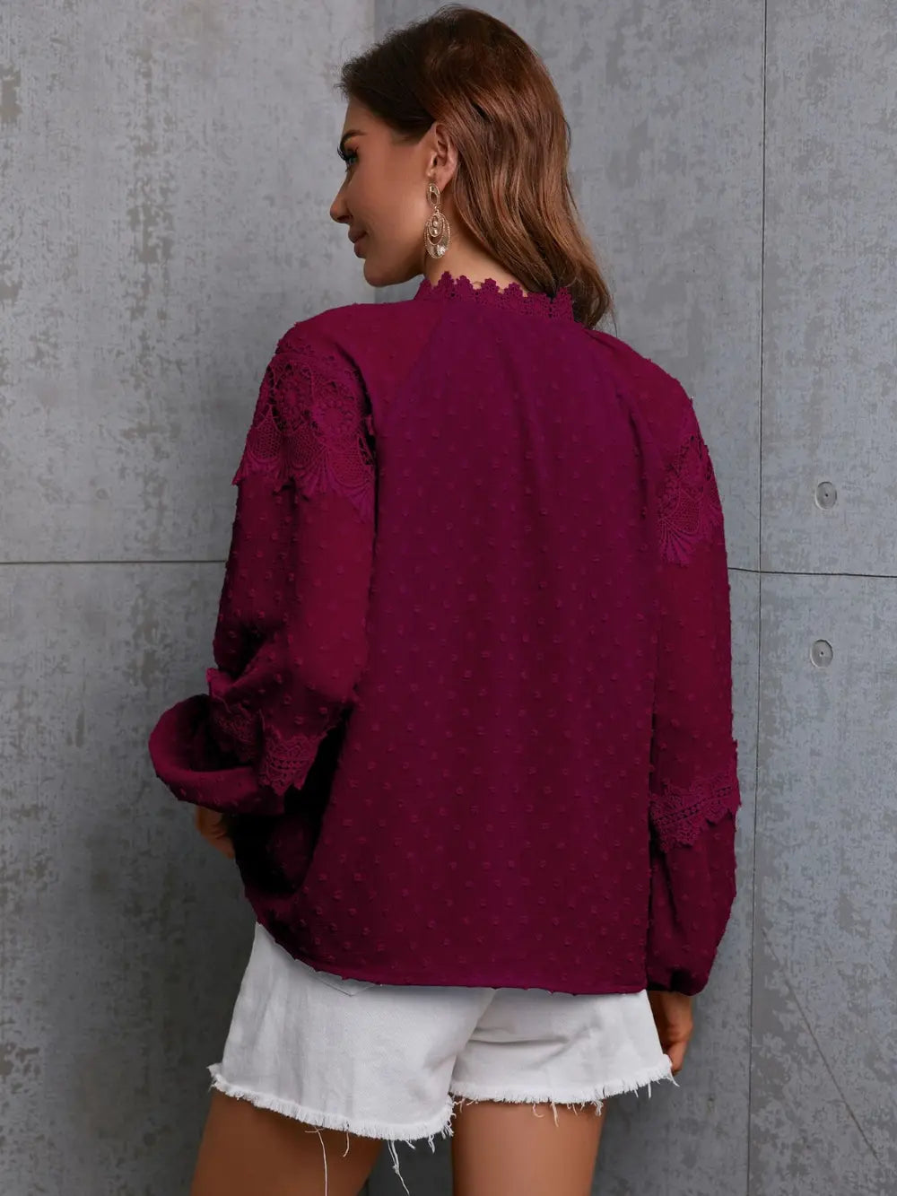 Close-up of the intricate crochet detailing and tassel ties on the neckline of the long sleeve blouse.