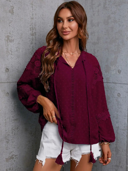 Model wearing the white crochet tassel tie neck blouse, styled casually with jeans for a relaxed look.