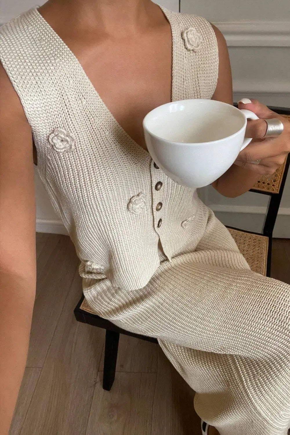 Side profile of a model wearing the tan knitted two-piece set, highlighting the skirt's drape.