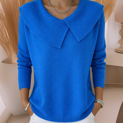 Full length shot of a blue knitted soft collar sweater, demonstrating its versatility when paired with trousers.