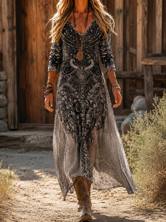 Front view of the flowing charcoal grey bohemian maxi dress, showcasing its elegant drape and long sleeves against a rustic outdoor background.