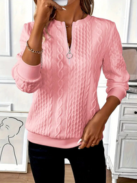 Woman enjoying a coffee, wearing the Alessia elegant knitted jumper, showcasing relaxed comfort.