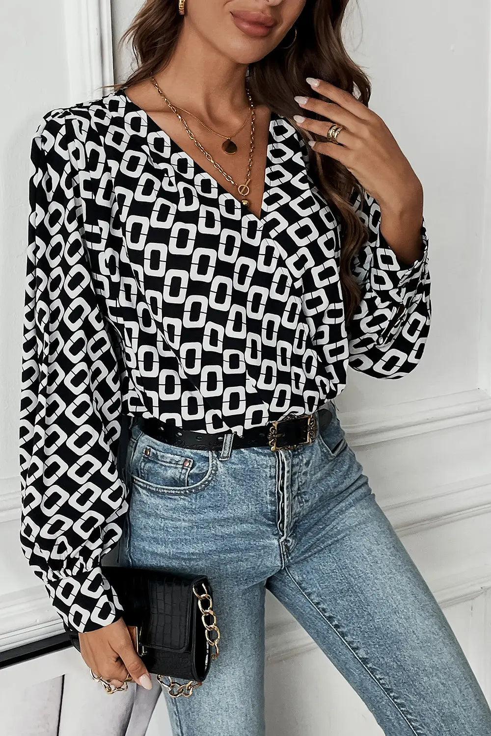 Side profile of a model wearing the black Nadia patterned blouse, demonstrating its relaxed fit and sleeve length.