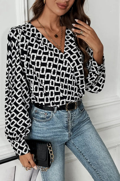 Side profile of a model wearing the black Nadia patterned blouse, demonstrating its relaxed fit and sleeve length.