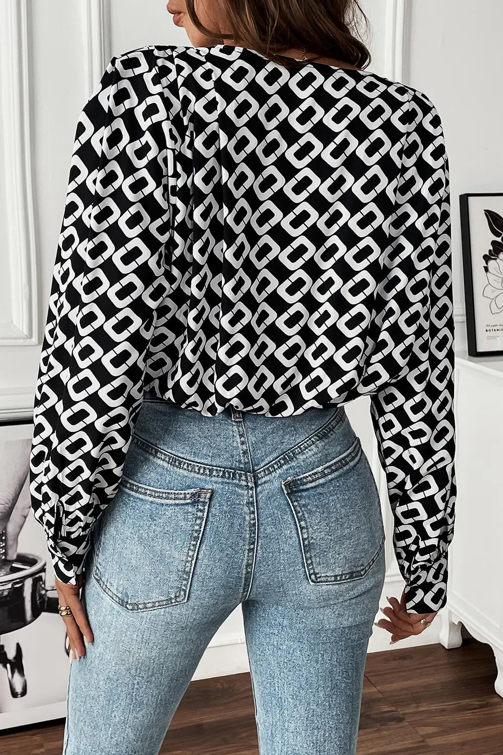Lifestyle shot of the Nadia patterned blouse styled with smart trousers, ideal for a professional work environment.