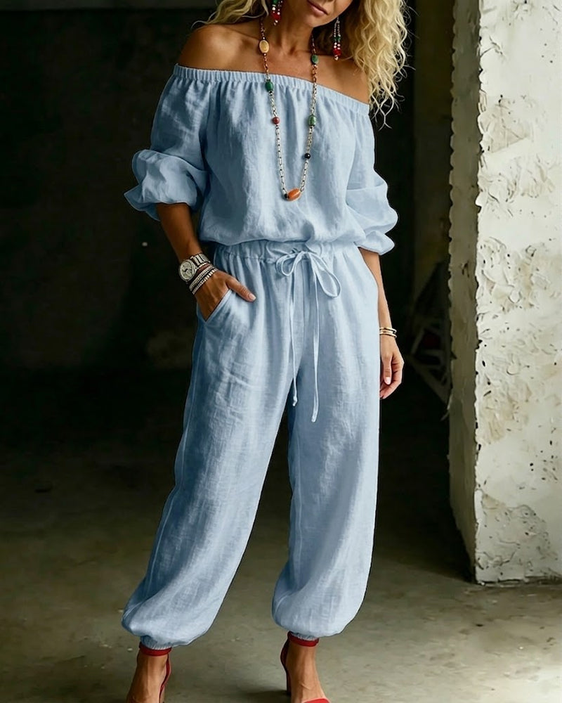 Front angled view of the Rhiannon off-shoulder cotton jumpsuit in a khaki colour, highlighting the generous leg width.