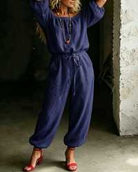 Front view of the Rhiannon off-shoulder cotton jumpsuit in a deep navy blue, exuding understated elegance.