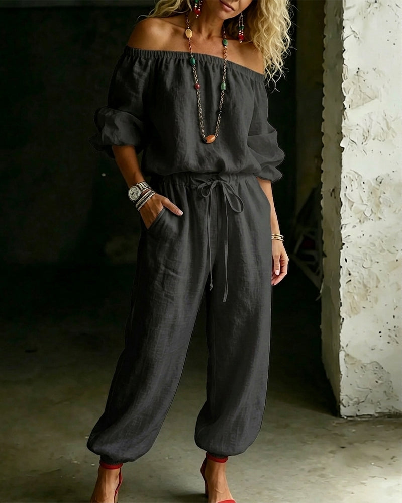 Model walking in the Rhiannon off-shoulder cotton jumpsuit, illustrating its movement and flow for a relaxed summer look.