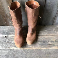 Close-up of the textured brown leather on the shaft of a cowgirl boot, highlighting the quality craftsmanship and subtle detailing.