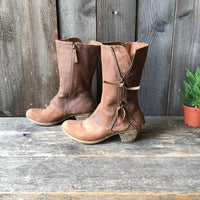 A pair of brown leather cowgirl boots styled with a flowy skirt, illustrating their versatility for a chic autumn ensemble.