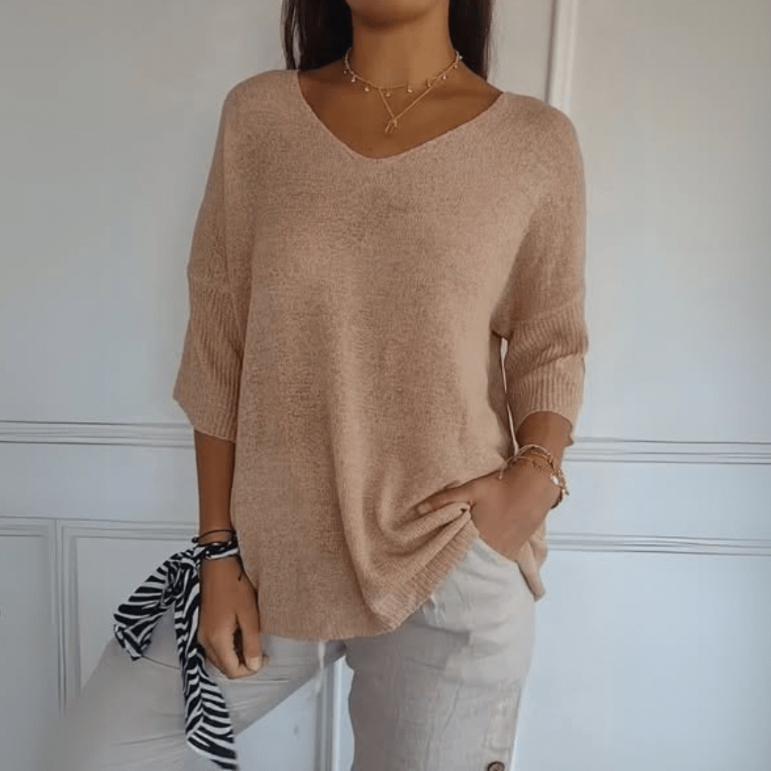 Close-up of the V-neckline and soft knit texture of the Ophelia loose sweater on a hanger.