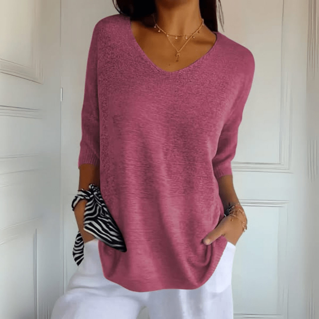 A woman casually posing in the Ophelia V-Neck loose sweater, paired with jeans for a relaxed look.
