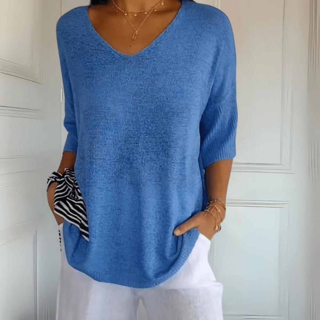 A stack of Ophelia V-Neck loose sweaters in various available colours, showcasing the range.