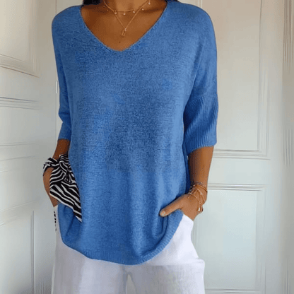 A stack of Ophelia V-Neck loose sweaters in various available colours, showcasing the range.