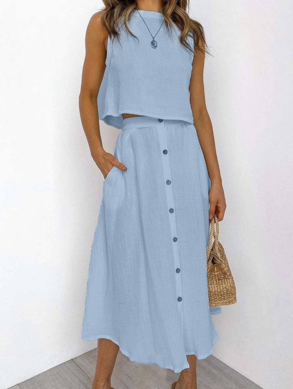 Close-up detail of the green Perla two-piece set's fabric texture and vest buttons, highlighting material quality.